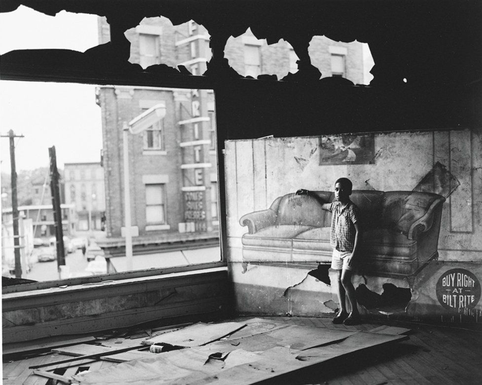 Boy in burnt out furniture store, Newark, 1969